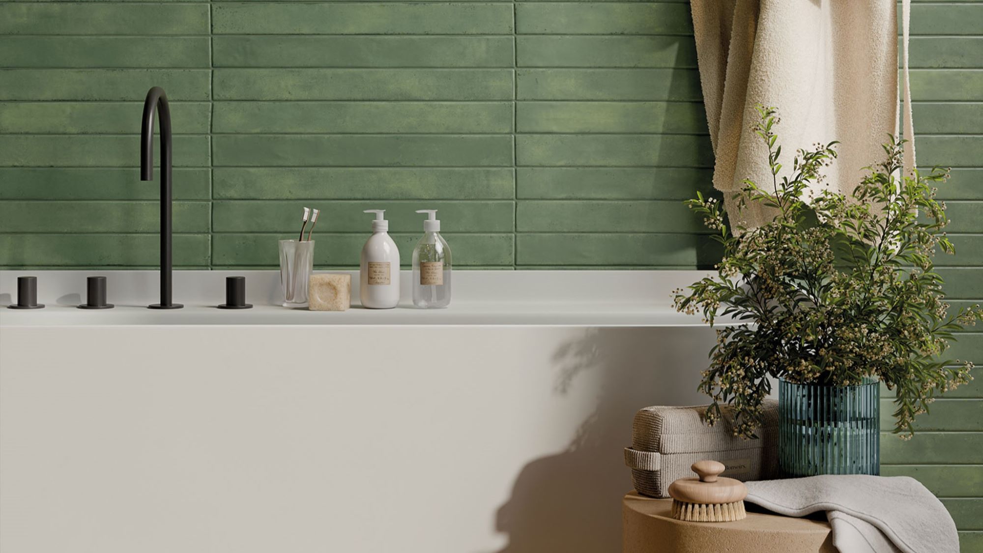 The image shows a modern bathroom with a white bathtub, a green tiled wall, and a variety of accessories, including a plant, towels, and a soap dispenser. The overall aesthetic is clean, minimalist, and inviting.